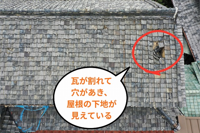 瓦が割れて穴があき、屋根の下地が見えている様子
