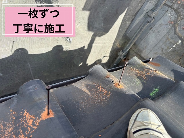 可児市長坂の屋根工事で、軒瓦を一枚ずつ確認しながらビス固定を行っている様子
