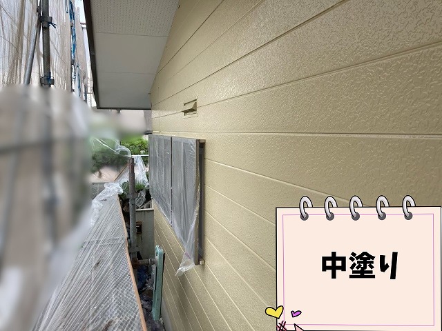 春日井市坂下町の住宅で外壁中塗りを施工している様子