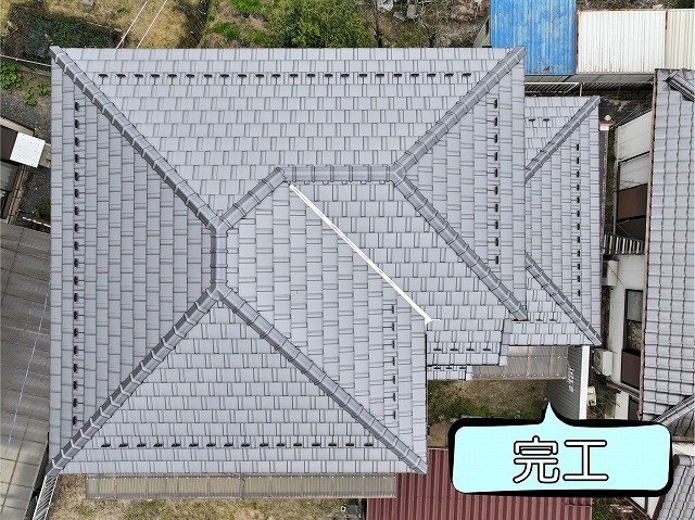 ドローン撮影による屋根全体の完成写真。平板瓦が美しく整列した大屋根と複雑な寄棟屋根の形状が確認できる