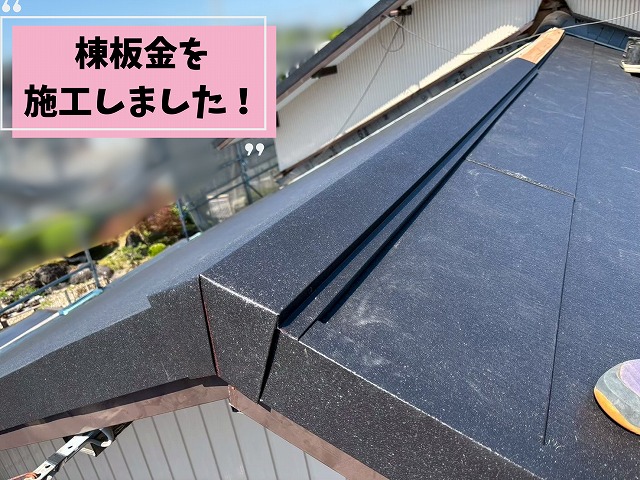 棟板金を施工し屋根の頂上部分を仕上げている様子
