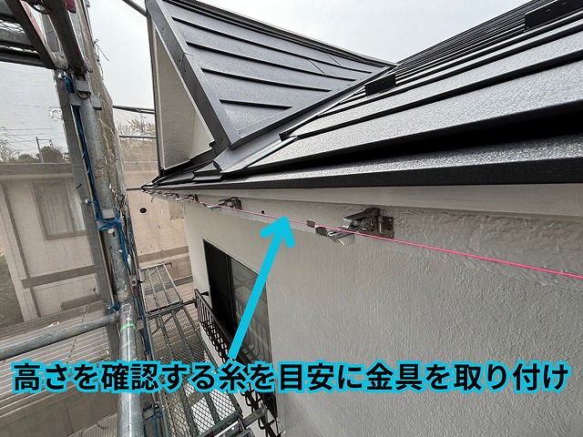 雨樋の高さを確認しながら金具を取り付け、水勾配を調整している施工中の様子