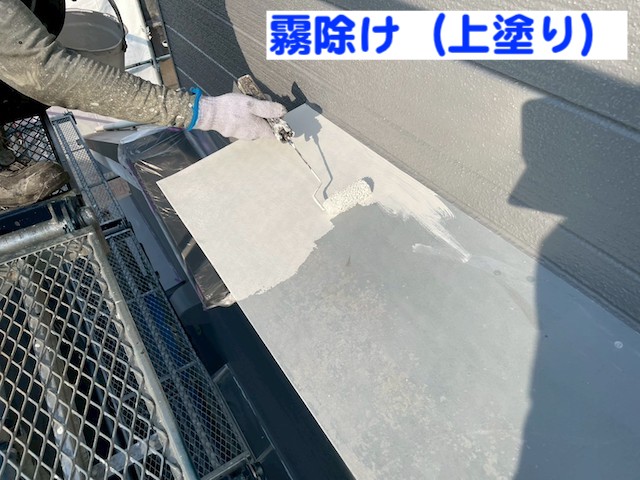 古河市　屋根工事をきっかけに足場を活用して外壁塗装　霧除け上塗り作業の写真　