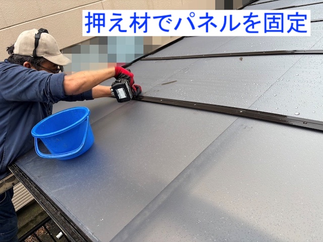 パネルの押え材にビス固定している風景