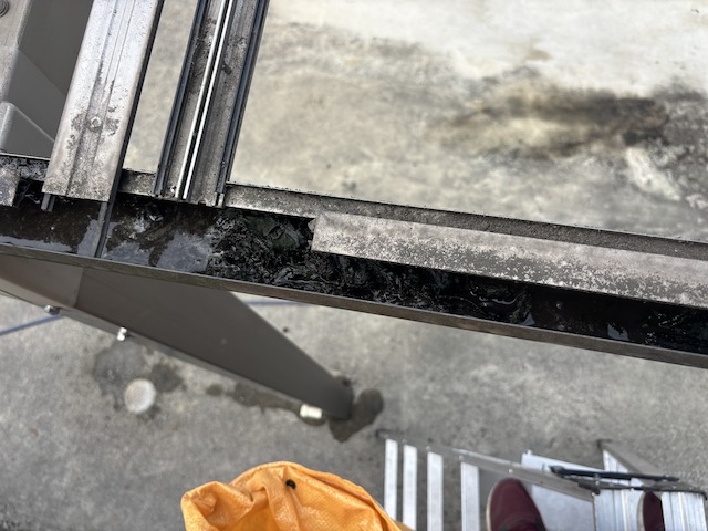 泥状の汚れが溜まった車庫の雨樋