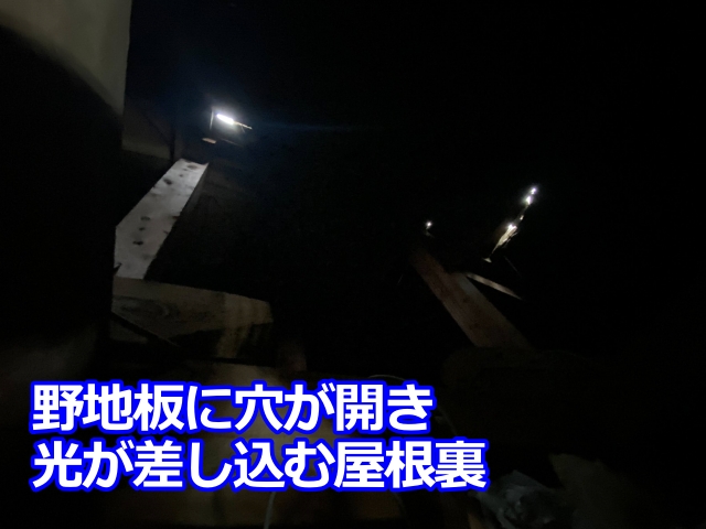 屋根裏の野地板に穴が開き、外の光が差し込んでいる