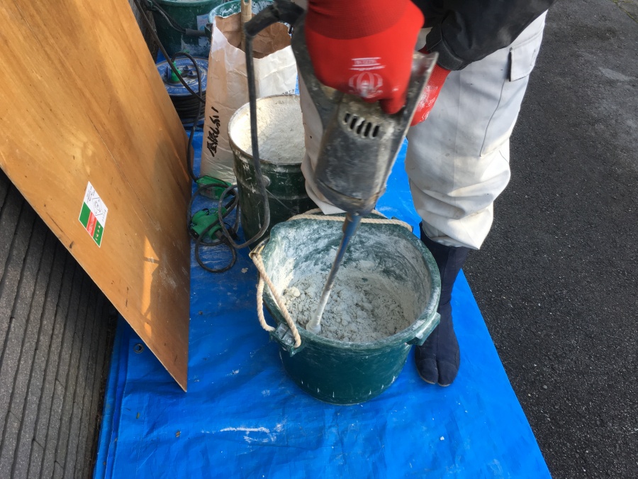 屋根用漆喰をバケツで撹拌している