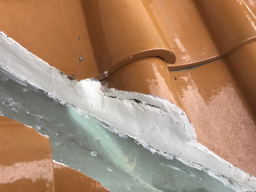 谷板金と瓦の隙間を漆喰で埋めて補修をしているようです。