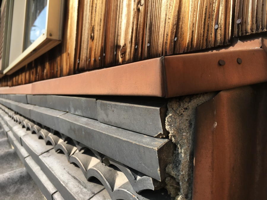 壁際に積まれた熨斗瓦が下垂している