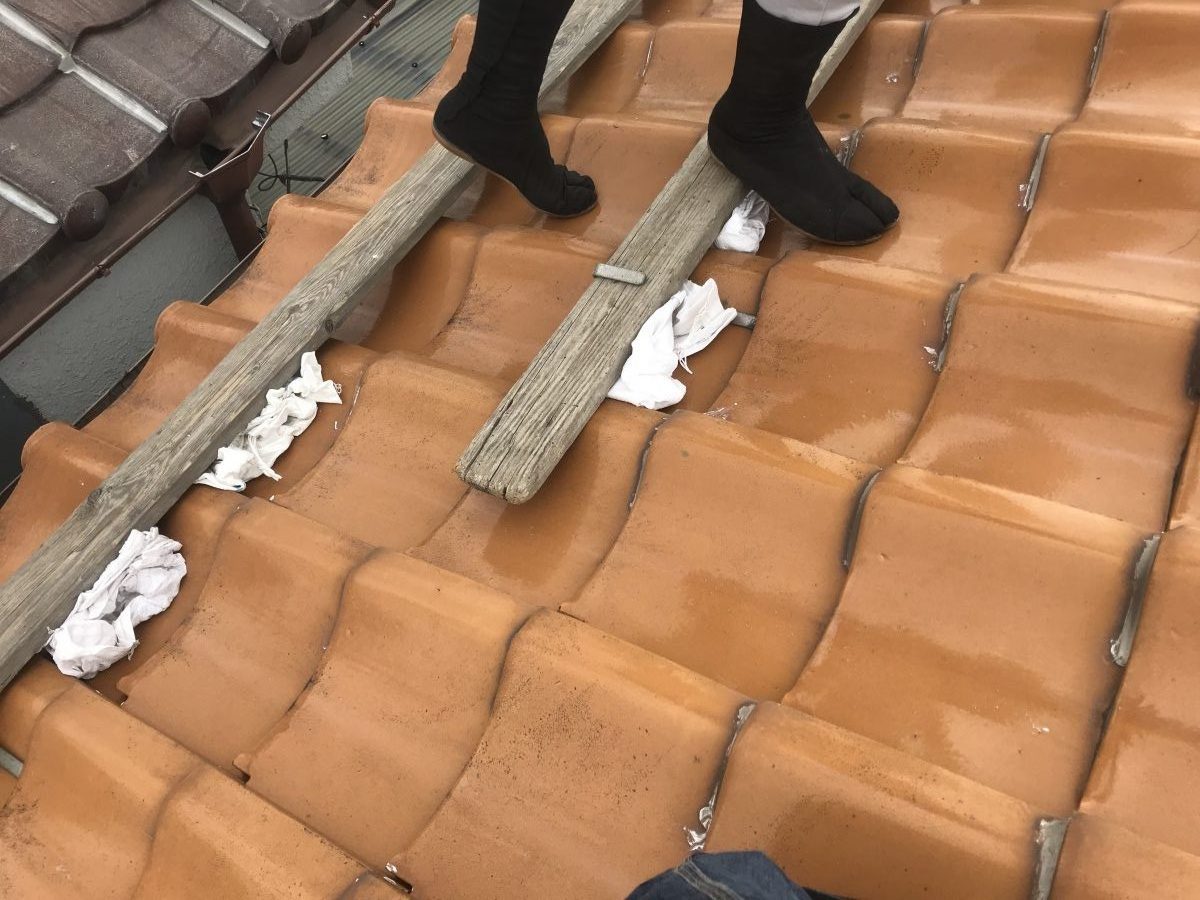 足場板の下に土嚢を詰め、土やゴミなどの転げ落ちを養生致します。