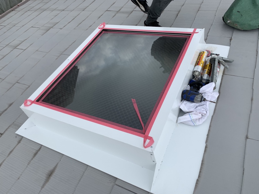 トップライト(天窓)の雨漏り修繕工事　　トップライト板金とガラスの間をマスキングテープで養生します。