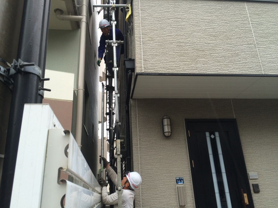 足場の解体　手摺の手渡しの様子