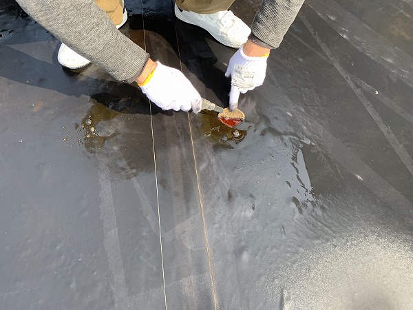 浮いた防水の下には赤く変色した雨水がたまっている状態です