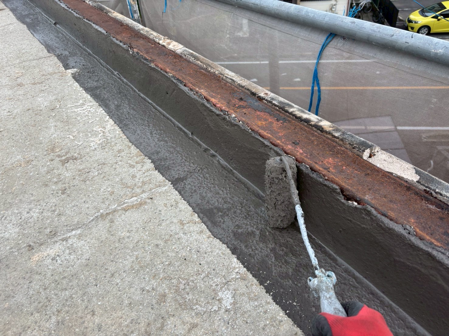 「クラック部分に樹脂モルタルを充填し、下地の凹凸を補修している様子