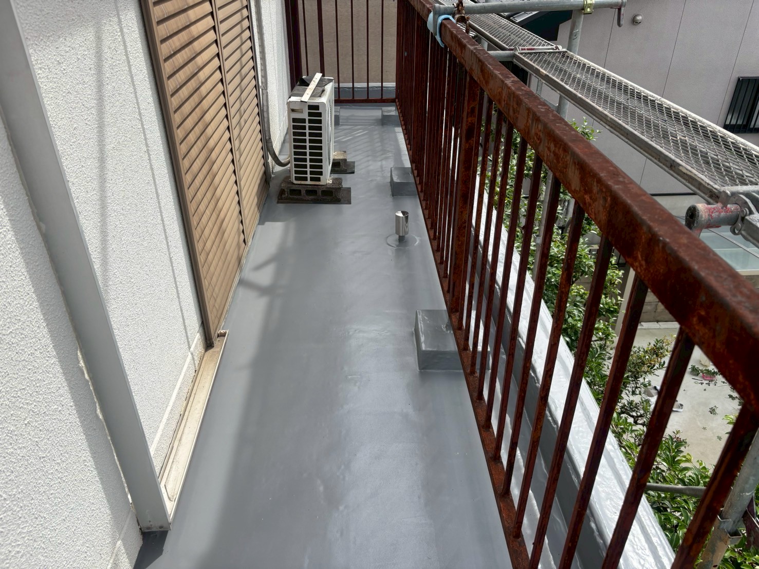 トップコート塗布中の写真 　「OTコートAをローラーで仕上げ塗りしている様子。防水層を紫外線から保護