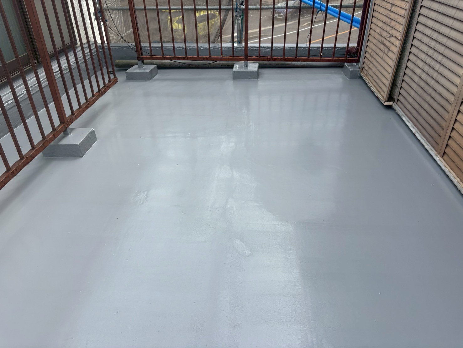 トップコート塗布中の写真 　「OTコートAをローラーで仕上げ塗りしている様子。防水層を紫外線から保護