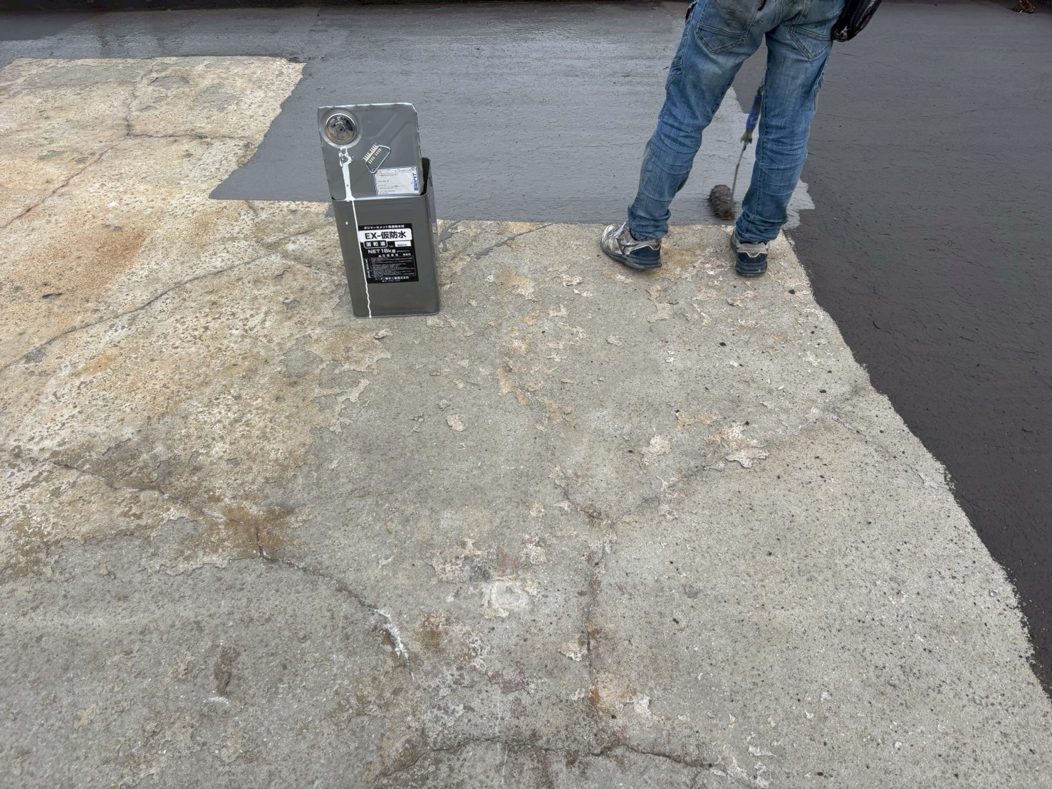 　「OTプライマーをローラーで均一に塗布している場面。下地との密着性を高める工程。」