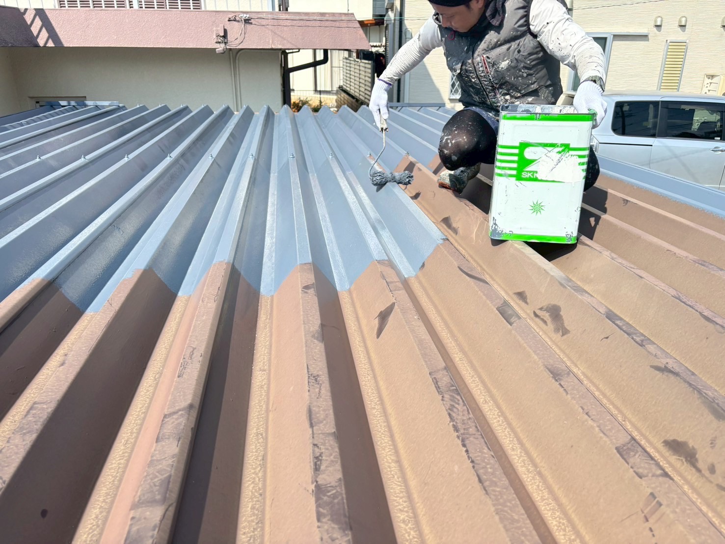 SK化研プレミアムルーフSiを塗装中の折板屋根の様子春日井市