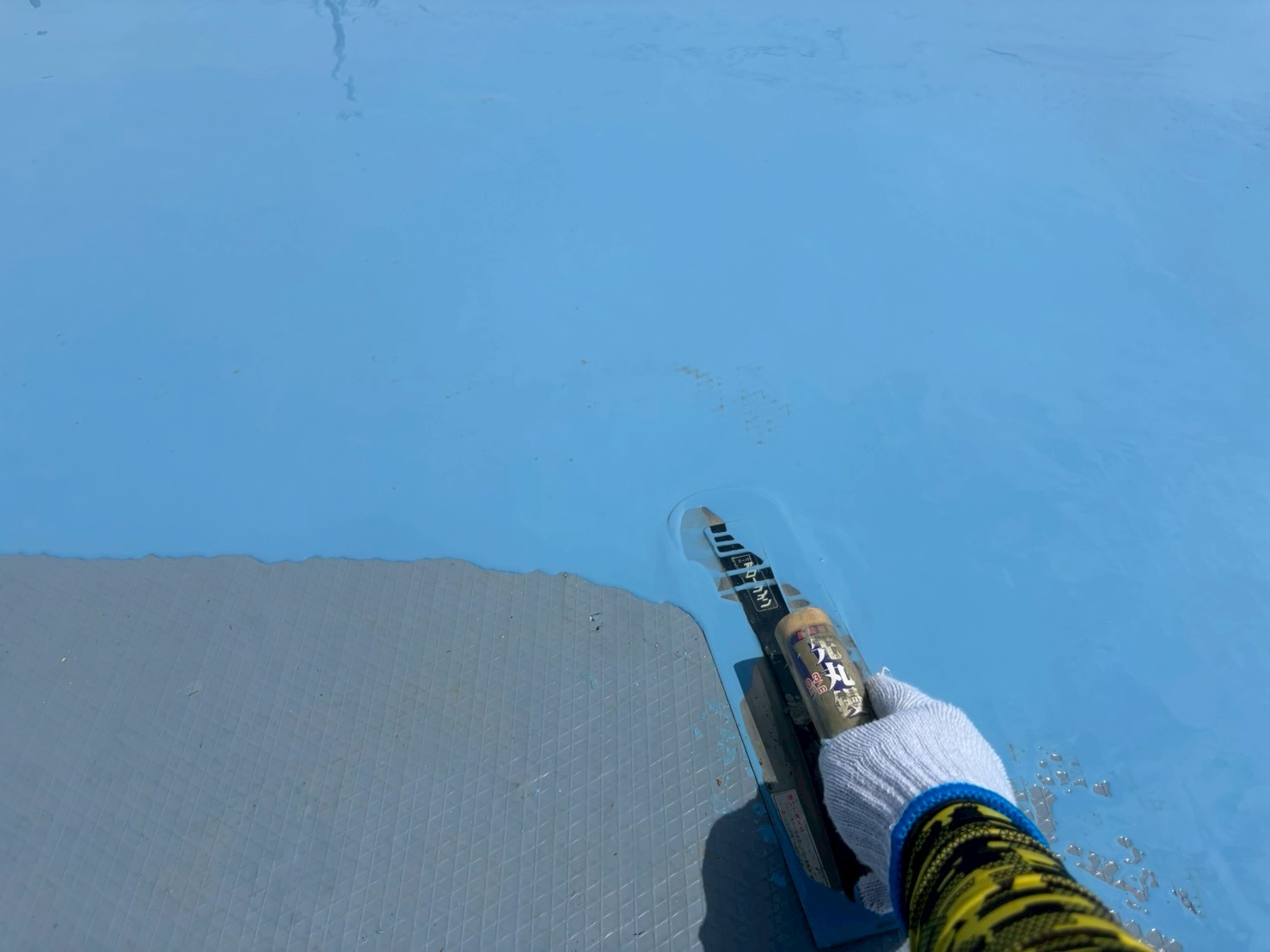 ウレタン塗布中の写真 　「オルタックエースUCを平場に塗布し、防水層を形成している様子