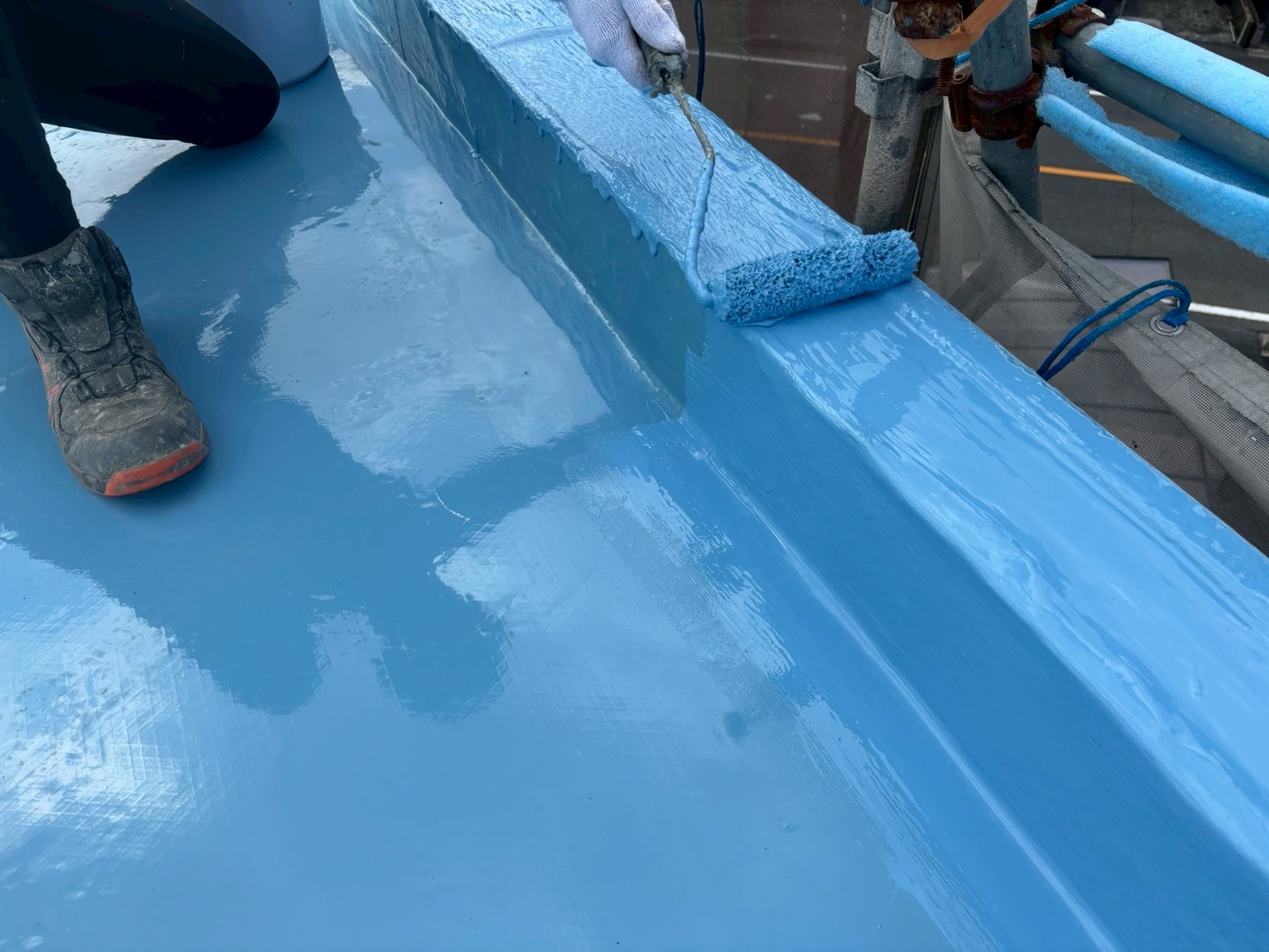 ウレタン塗布中の写真 　「オルタックエースUCを平場に塗布し、防水層を形成している様子