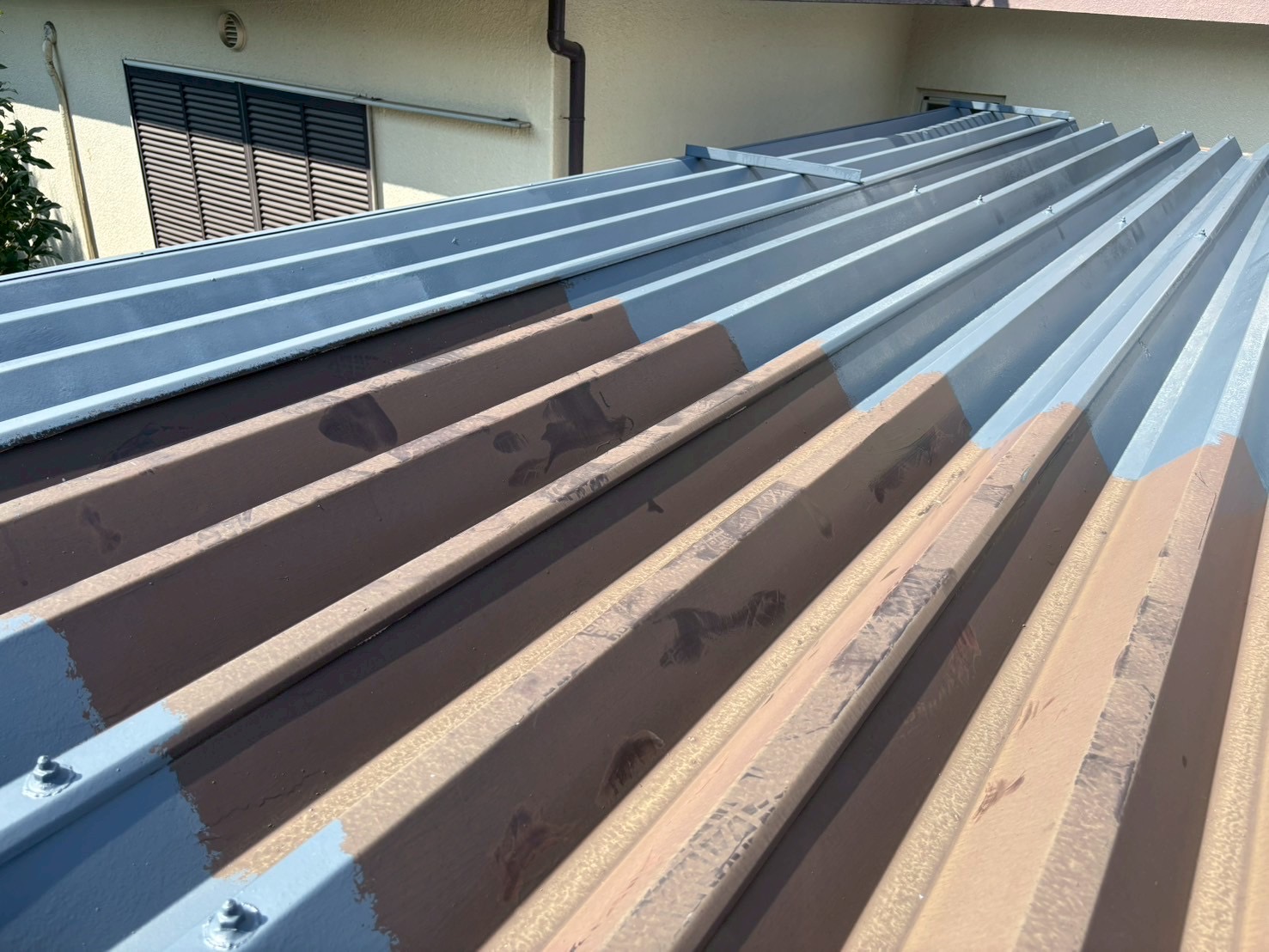 SK化研プレミアムルーフSiを塗装中の折板屋根の様子