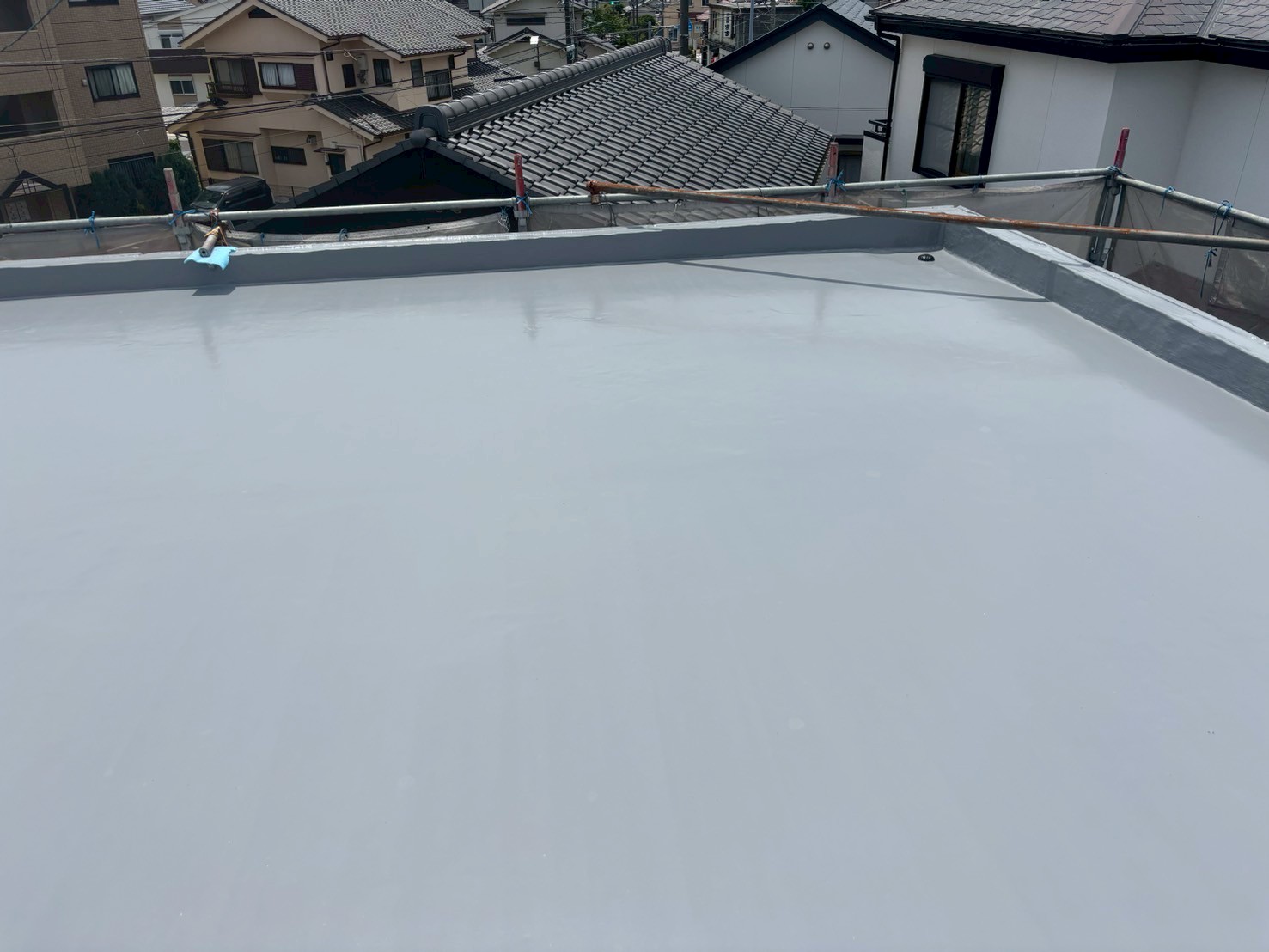 トップコート塗布中の写真 　「OTコートAをローラーで仕上げ塗りしている様子。防水層を紫外線から保護