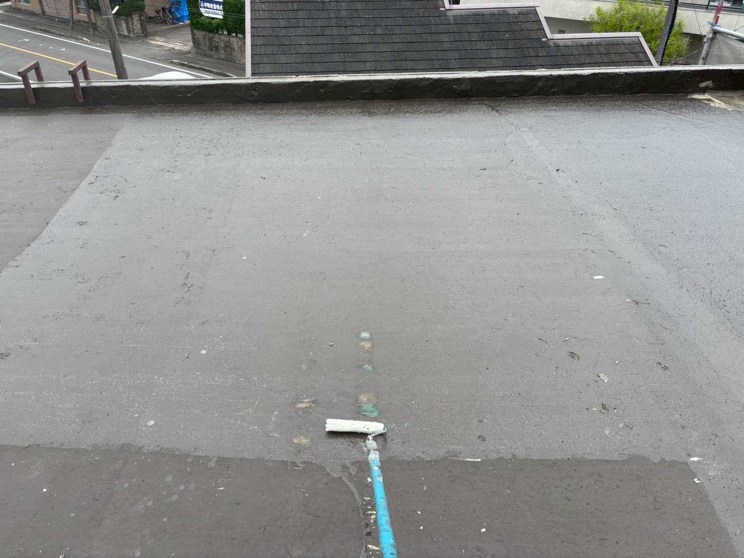 　「OTプライマーをローラーで均一に塗布している場面。下地との密着性を高める工程。」