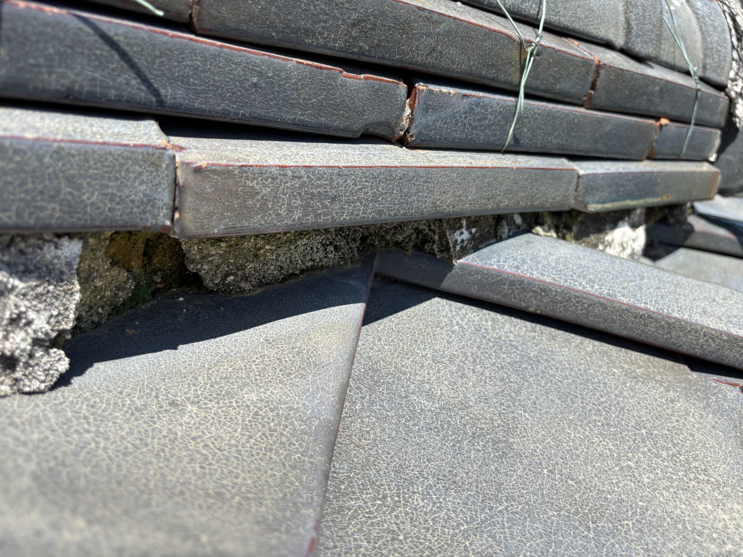 小牧市の瓦屋根で棟下漆喰が剥がれて葺き土が露出している様子
