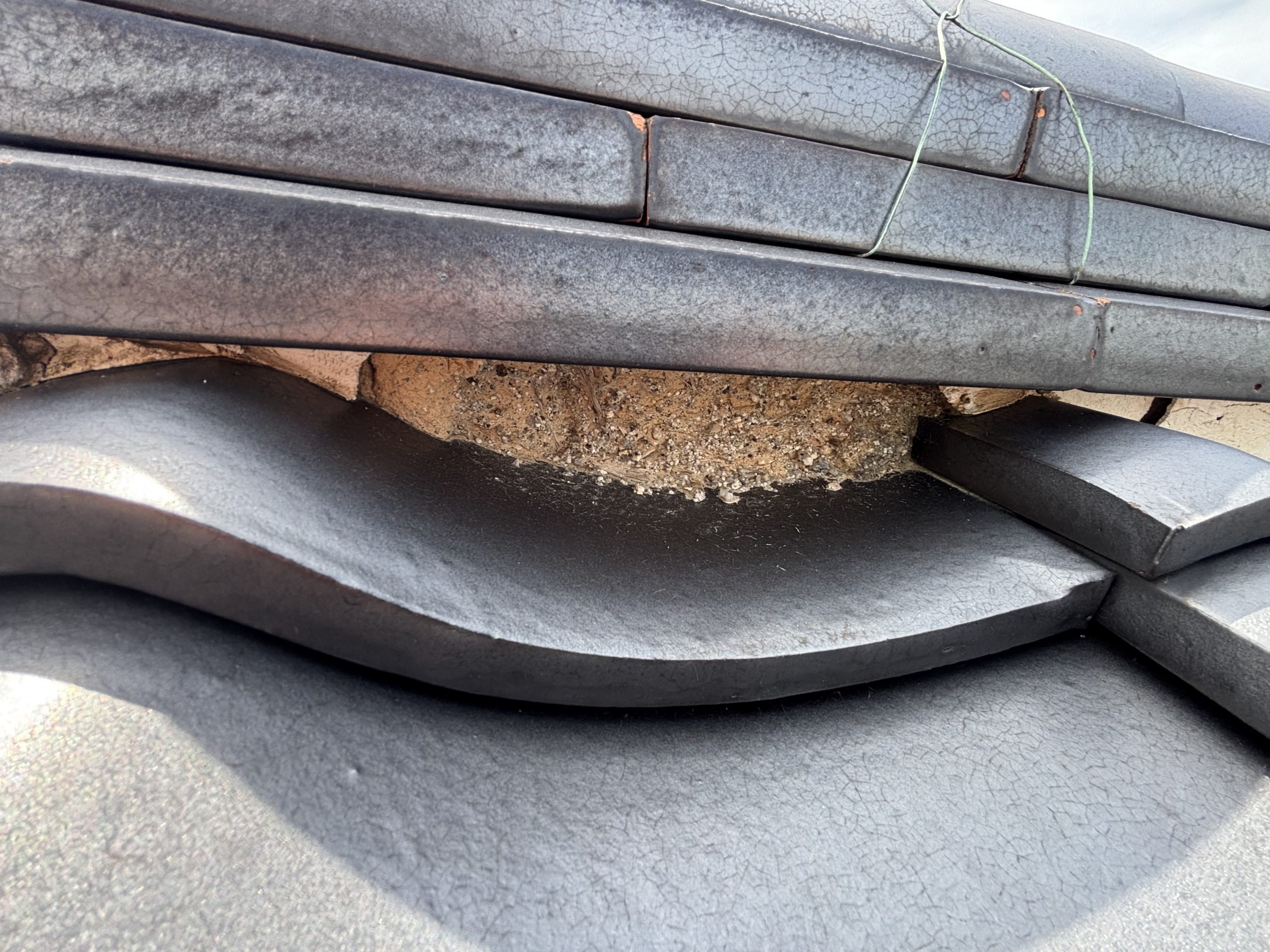 春日井市の住宅屋根で確認された漆喰の剥がれと銅板の腐食による穴あき部分