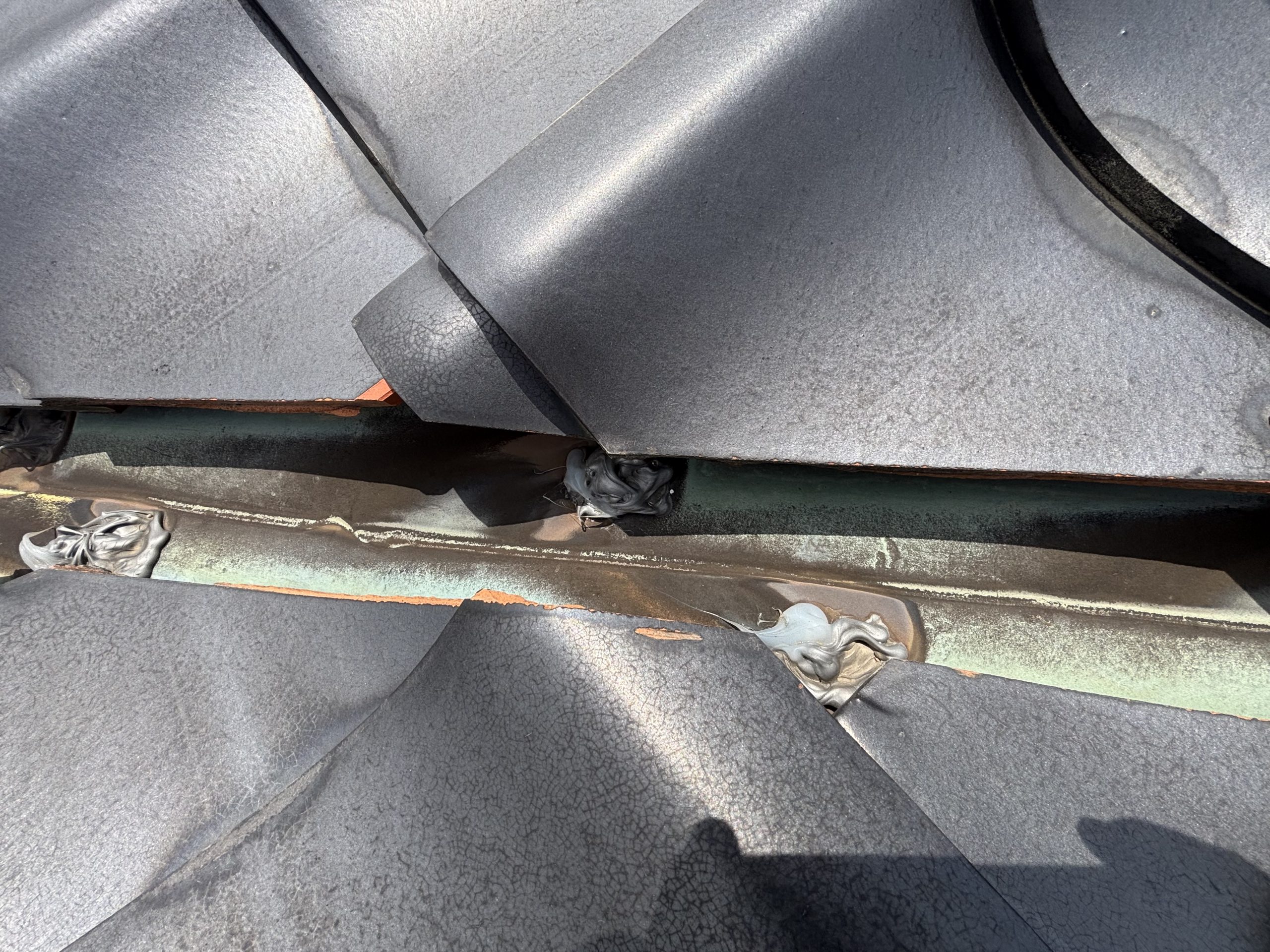 春日井市の住宅屋根で確認された漆喰の剥がれと銅板の腐食による穴あき部分