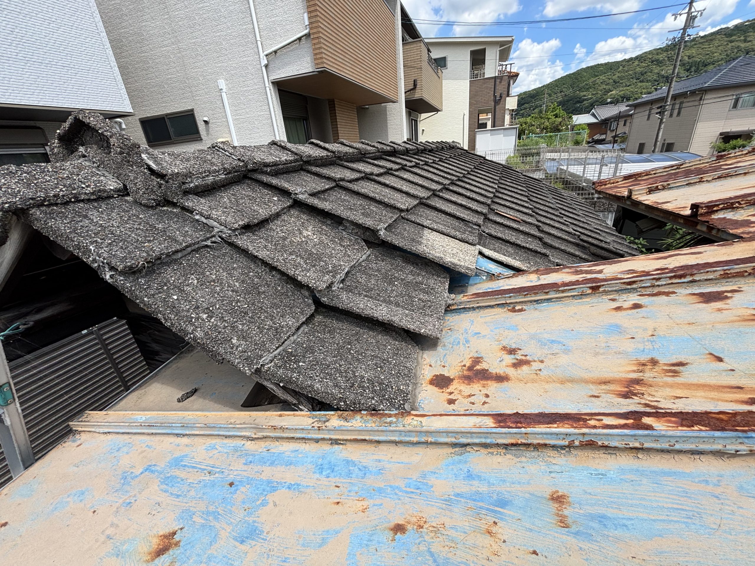 古いセメント瓦の割れや色あせを確認している様子