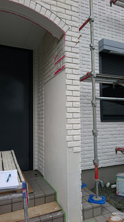 外壁と同じようなタイルを貼って壁をデザインしていく風景