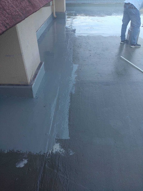 店舗屋上にてトップコートの塗り作業