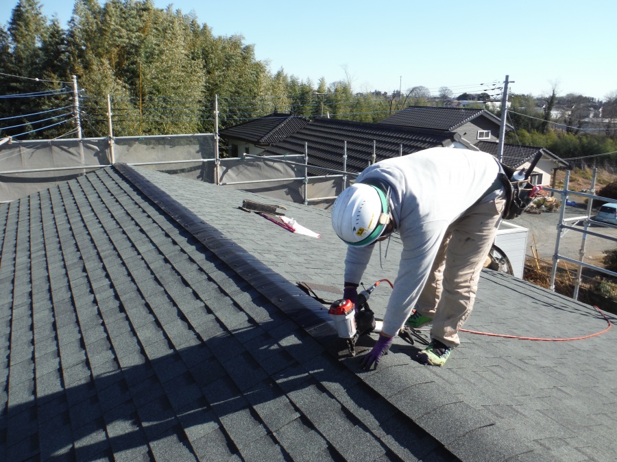 棟換気口(むねかんきこう)を専用のくぎ打ち機を使い、取り付けている作業員さん