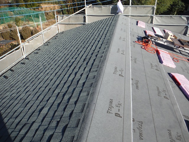 屋根材貼り付け作業の途中経過で、片側だけ屋根材が貼り終わった写真