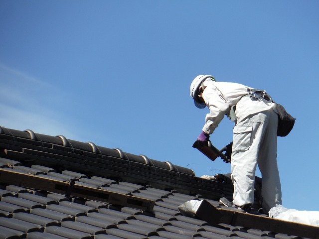 既存の瓦を取り外している作業員