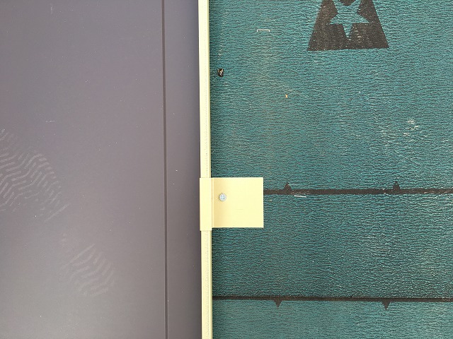 取り付けた板金屋根材の端に取り付けられる吊り子金具