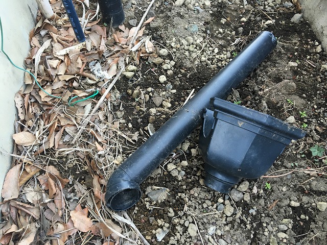 落ち葉の上に置かれている黒色の横樋と集水器