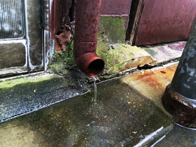 水が流れ落ちる赤い雨樋