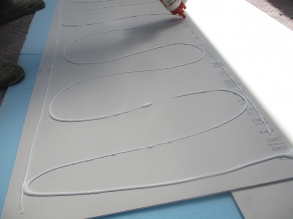 新規の軒天材にボンドを塗布中です