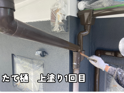 奈良市の住宅で竪樋の耐久性を高めるためシリコン塗装1回目を施工している様子