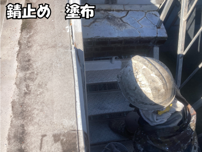 赤サビ除去後の鉄骨階段に錆止め塗料を丁寧に塗布している下塗り工程
