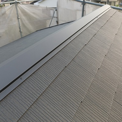 生駒市の屋根葺き替え工事で新しく取り付けられた棟板金の施工完了部分