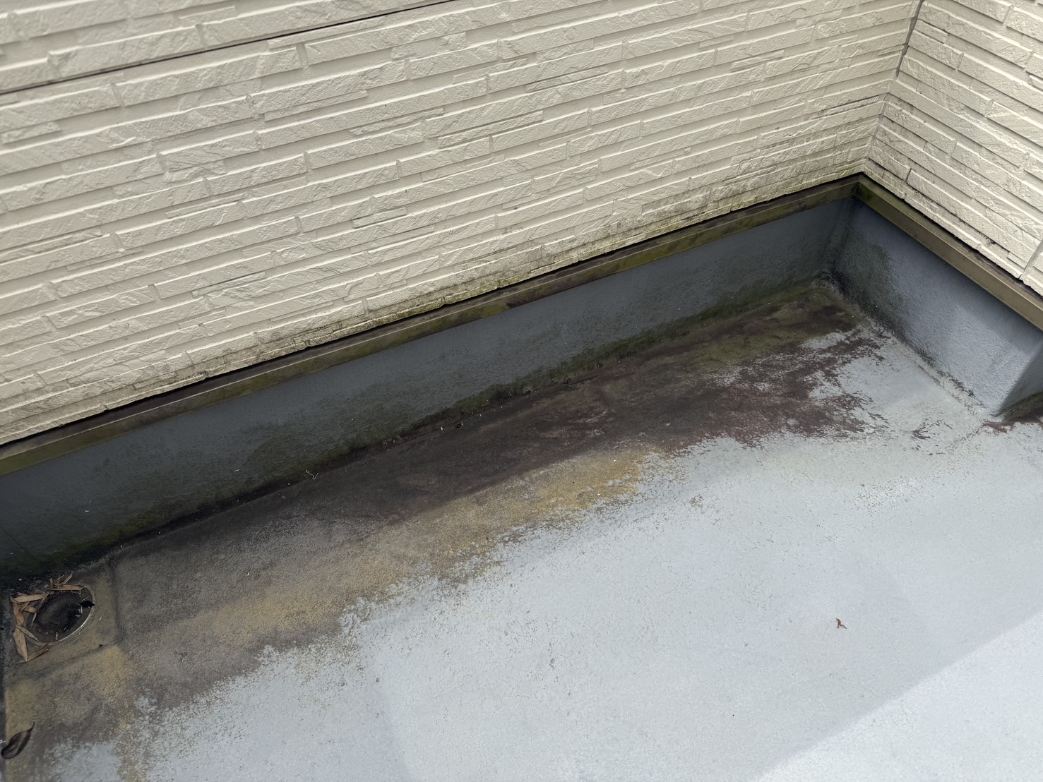 生駒市ベランダの床が黒ずんで劣化している