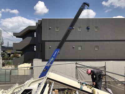 屋根材を張る作業員