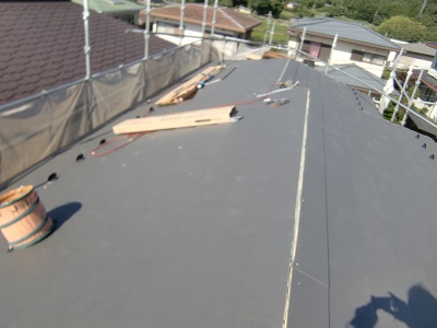 金属の屋根材を被せていく様子