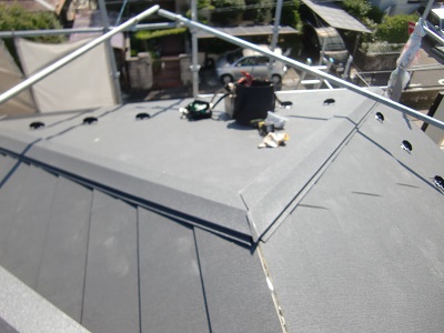 屋根の継ぎ目に垂木と棟板金を被せる様子