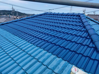 セメント洋瓦に下塗り材を塗装している様子