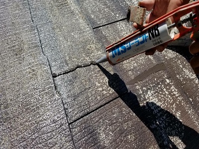 ひび割れたスレート屋根の塗装工事の塗装前準備の様子