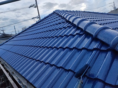 セメント洋瓦に塗料本材を塗装している様子